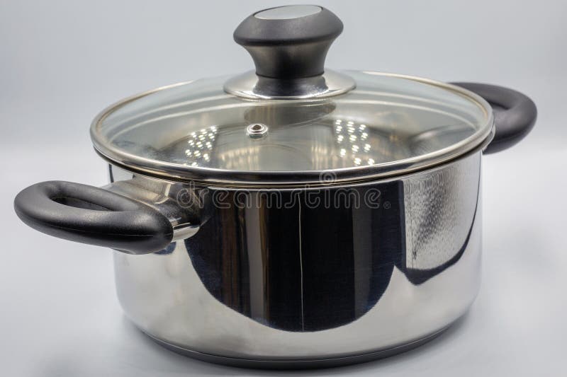 Studio shoot of large shiny stainless steel empty new saucepan closeup on white. Traditional big metal pot stock images, royalty-free photos and pictures