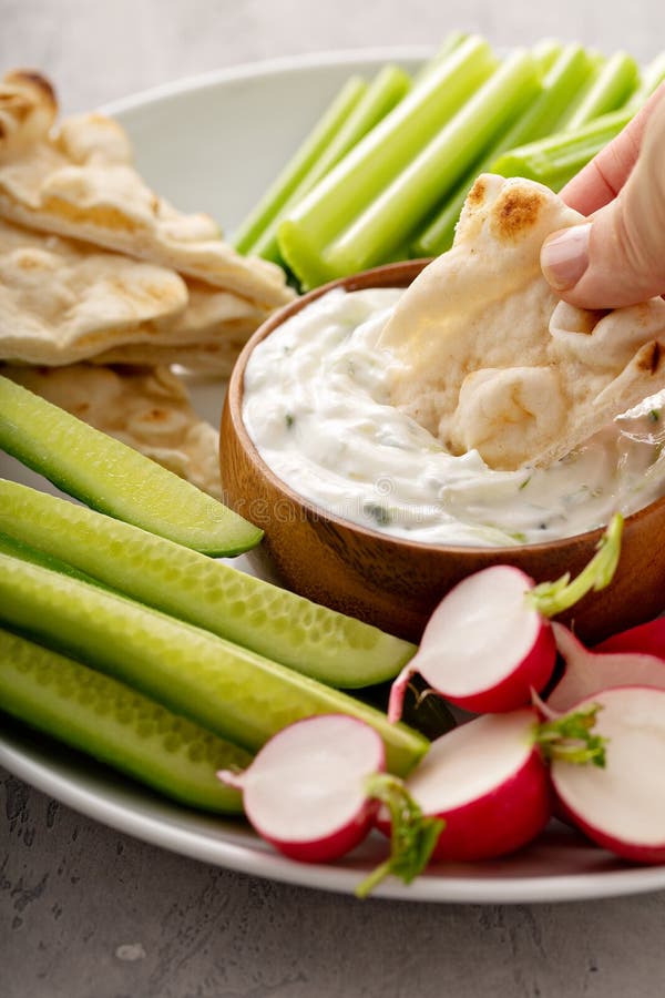 Large snack board with tzatziki dip or sauce and fresh vegetables