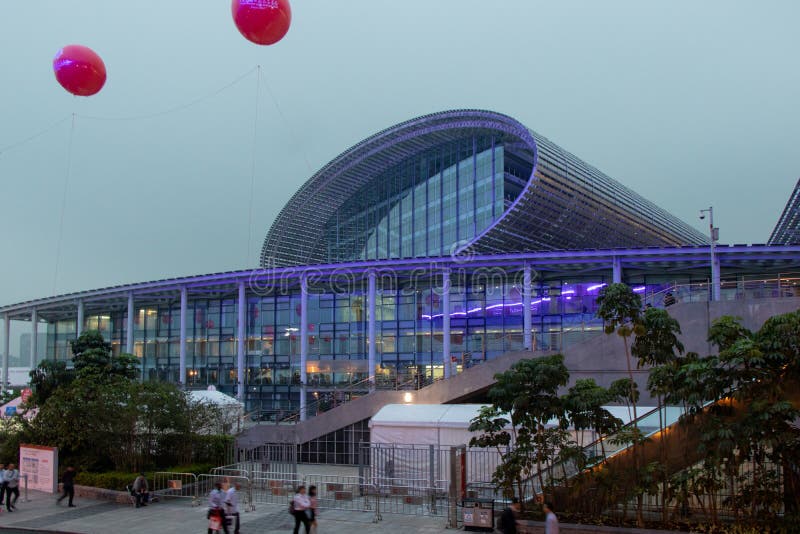 Large steel and glass building. Oval roof of the building, blue lights, stone stairs. Red gel balls in the air. royalty free stock photos Large steel and glass building. Oval roof of the building, blue lights, stone stairs. Red gel balls in the air. royalty free stock photos