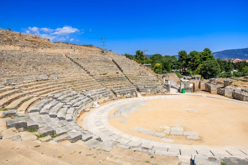 A large stone amphitheater with a green trash can in the middle. Ruins of the ancient city of Philippi, Greece royalty free stock image