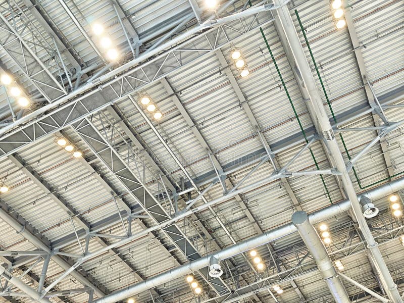 Bright ceiling with metal beams and lights highlights the spacious design of an industrial space, emphasizing its modern architecture. Industrial lights stock images, royalty-free photos and pictures