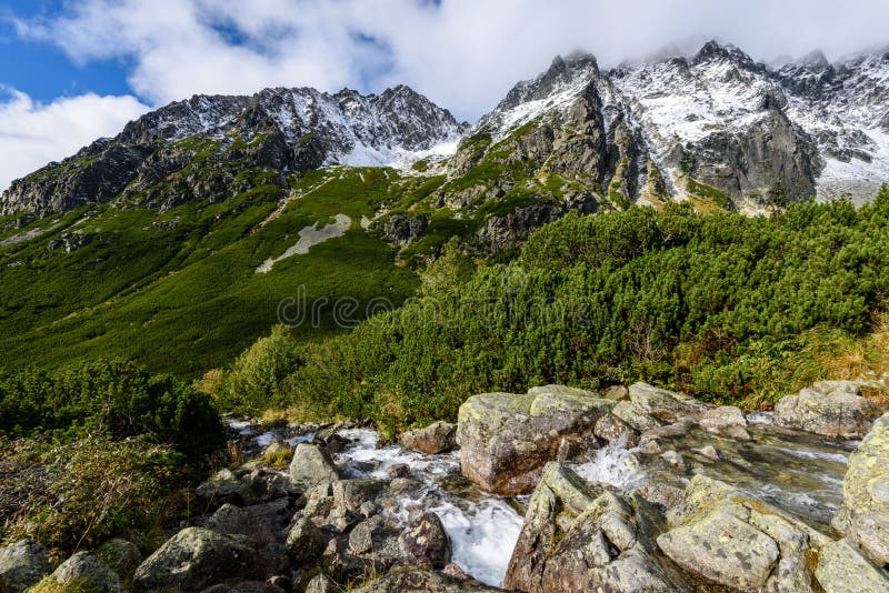 Velký vodopád z rokle na podzim, dlouhá expozice s horami v pozadí