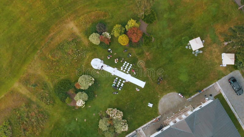 Large wedding venue with white arch and walkway by chairs