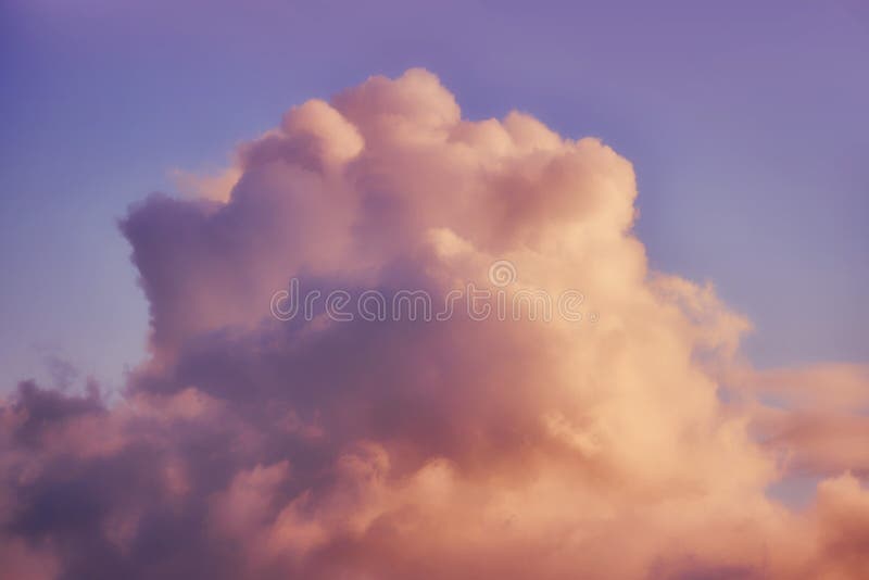 A large white cloud against a warm blue sunset sky