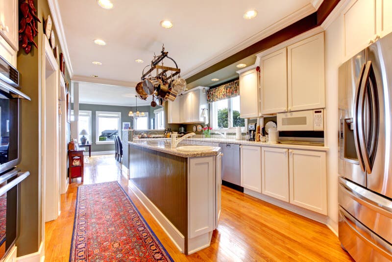 Large white and green kitchen with hardwood floor. stock images