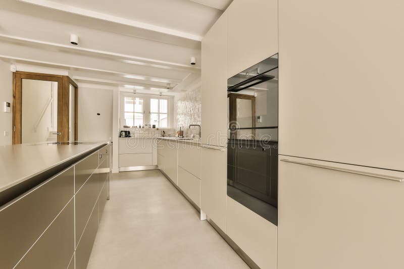 a modern kitchen with white cabinets and black oven hoods on the wall above the countertop in an open space. a modern kitchen with white cabinets and black oven hoods on the wall above the countertop in an open space