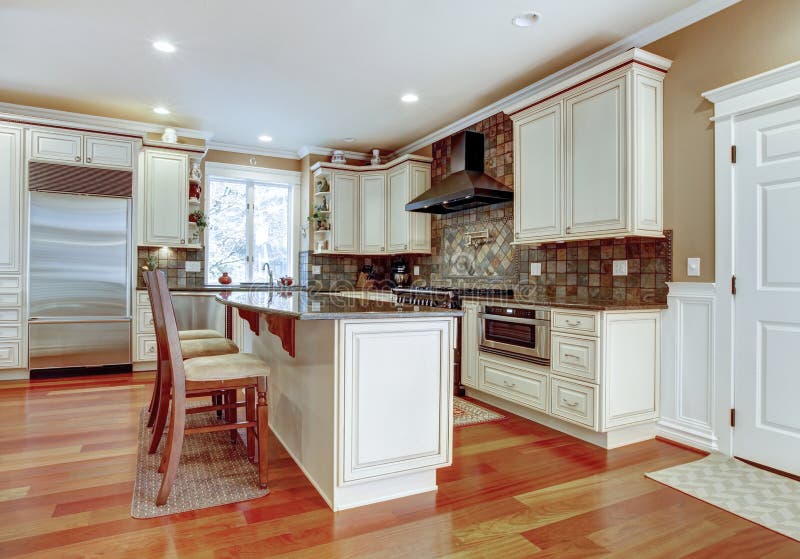 Large white luxury kitchen with cherry hardwood. royalty free stock photo
