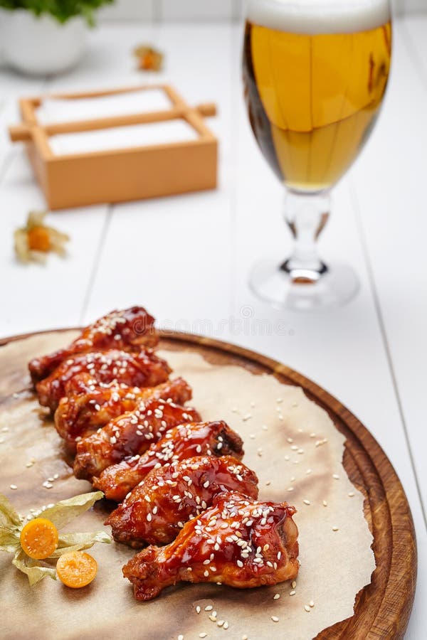 Las alas de pollo del búfalo frieron en salsa con el vidrio de cerveza foto de archivo libre de regalías Las alas de pollo del búfalo frieron en salsa con el vidrio de cerveza foto de archivo libre de regalías