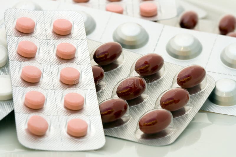 Silver gray medicine blisters with pink and red pills - close up shot. Silver gray medicine blisters with pink and red pills - close up shot