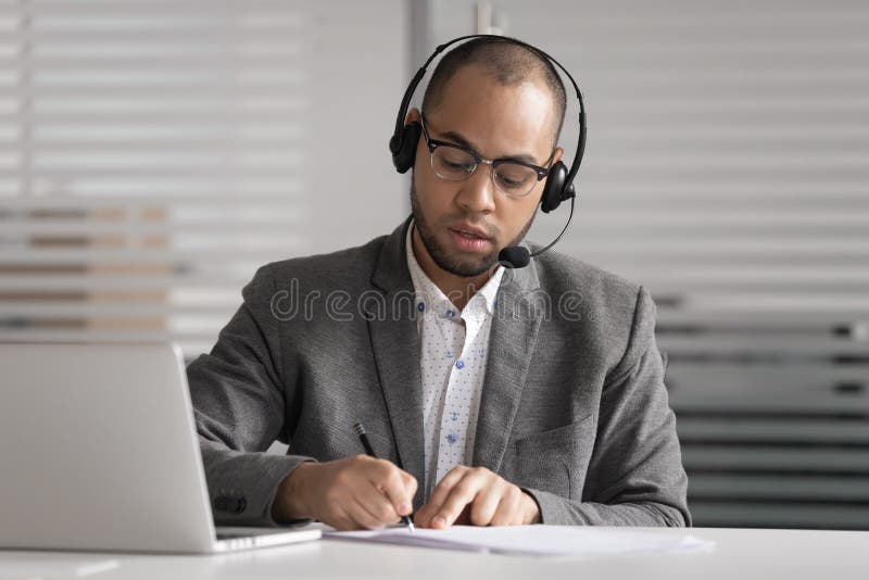 Las auriculares africanas del desgaste del agente de la atención al cliente escribir notas hacen la llamada video