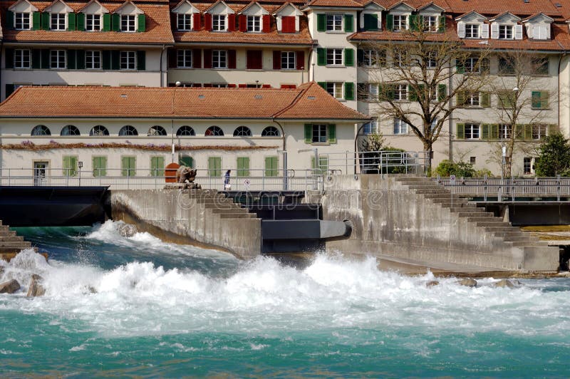 Floodgates or flood locks on the river Aare in Bern, Switzerland. They regulate the water flow. There are historic residential houses built along the riverbank. Floodgates or flood locks on the river Aare in Bern, Switzerland. They regulate the water flow. There are historic residential houses built along the riverbank.