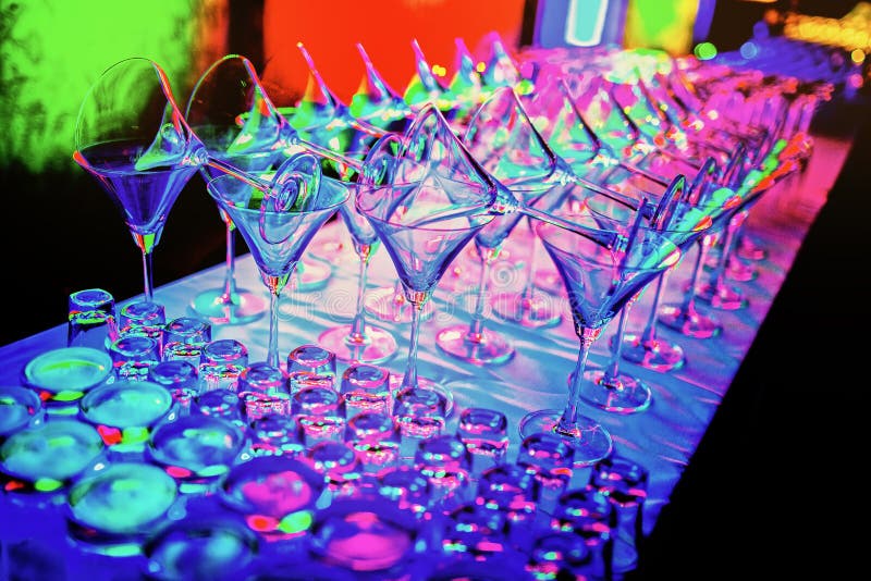 Las copas de vino vacías coloridas coinciden en el contador de la barra en el partido del club nocturno imagenes de archivo Las copas de vino vacías coloridas coinciden en el contador de la barra en el partido del club nocturno imagenes de archivo