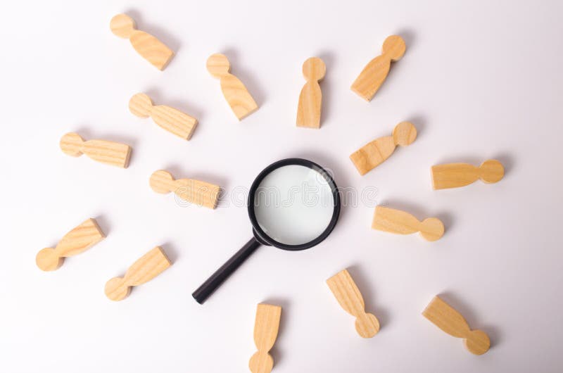 Las figuras de madera de la gente mienten alrededor de una lupa en un fondo blanco El concepto de la búsqueda para la gente y los imagenes de archivo Las figuras de madera de la gente mienten alrededor de una lupa en un fondo blanco El concepto de la búsqueda para la gente y los imagenes de archivo