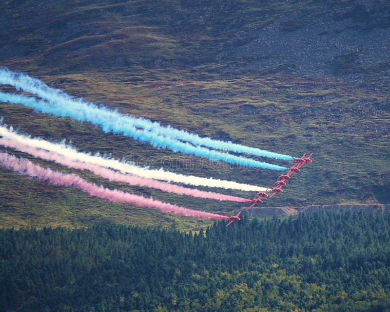 Las flechas rojas de la RAF con sendero de humo rojo, blanco y azul y las Montañas de Mourne en el fondo, Irlanda del Norte, 7 de fotos de archivo libres de regalías Las flechas rojas de la RAF con sendero de humo rojo, blanco y azul y las Montañas de Mourne en el fondo, Irlanda del Norte, 7 de fotos de archivo libres de regalías