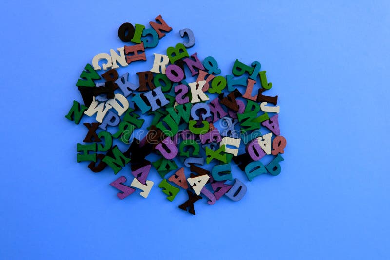 Las Letras Del Alfabeto Se Reparten Al Azar En Un Fondo Azul. Imagen de