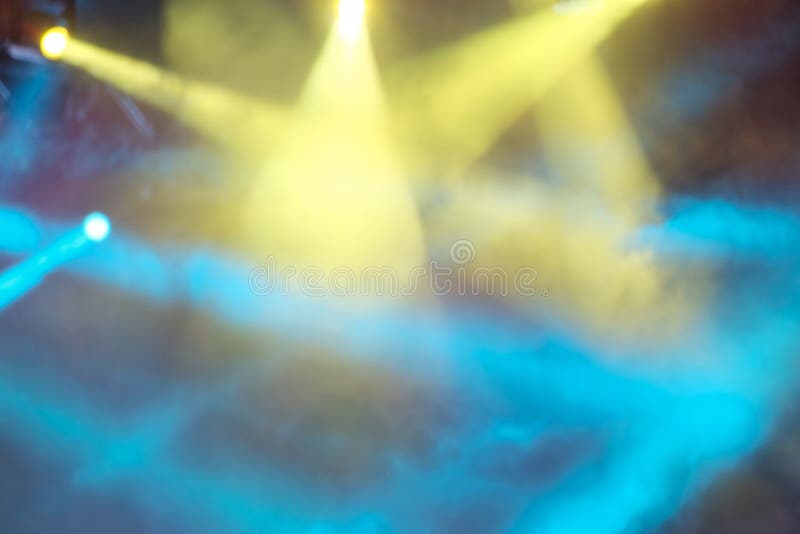 Las luces amarillas y azules del concierto brillan a través del humo Fondo hermoso abstracto de rayos de la luz multicolores bril fotografía de archivo libre de regalías Las luces amarillas y azules del concierto brillan a través del humo Fondo hermoso abstracto de rayos de la luz multicolores bril fotografía de archivo libre de regalías