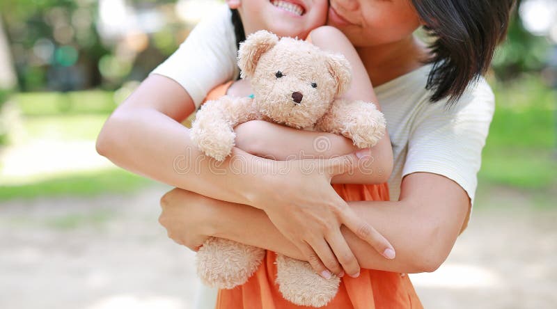 Las Manos De La Mamá Abrazan A La Hija Y Abrazan A La Muñeca De Peluche. Madre E Hijo Con Amor Y Concepto De Relación Imagen de archivo - Imagen de muñeca,