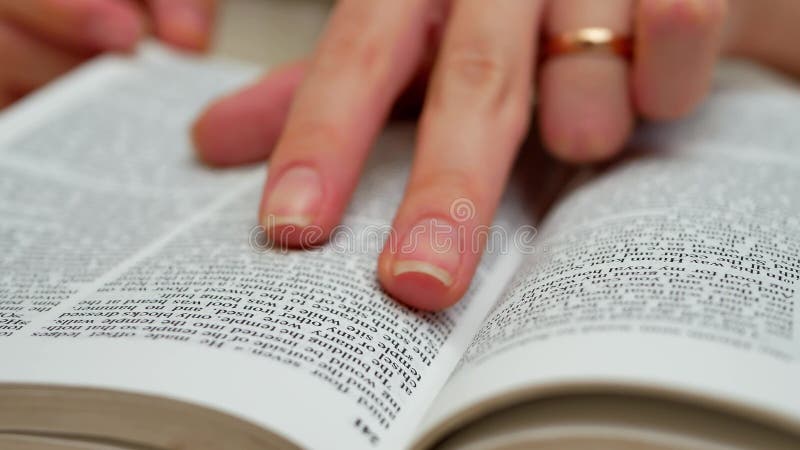 Las manos de la mujer abren el libro en la información de la tabla y del hallazgo