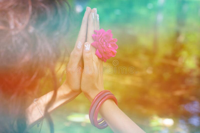 Las manos de la mujer con la flor en mudra de la yoga gesticulan al aire libre en naturaleza fotografía de archivo libre de regalías Las manos de la mujer con la flor en mudra de la yoga gesticulan al aire libre en naturaleza fotografía de archivo libre de regalías