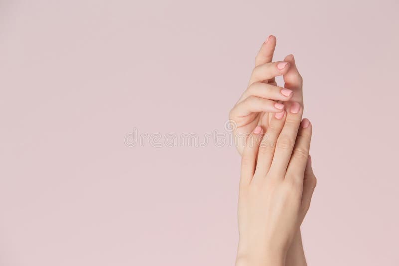 Las manos de la mujer con la piel limpia y los clavos con rosa pulen la manicura en fondo rosado Cuidado de los clavos y tema de foto de archivo libre de regalías Las manos de la mujer con la piel limpia y los clavos con rosa pulen la manicura en fondo rosado Cuidado de los clavos y tema de foto de archivo libre de regalías