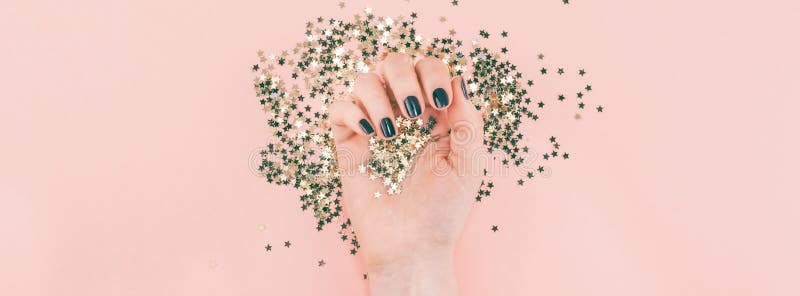 Las manos de la mujer cubrieron confeti de oro de las estrellas en rosa fotos de archivo libres de regalías Las manos de la mujer cubrieron confeti de oro de las estrellas en rosa fotos de archivo libres de regalías
