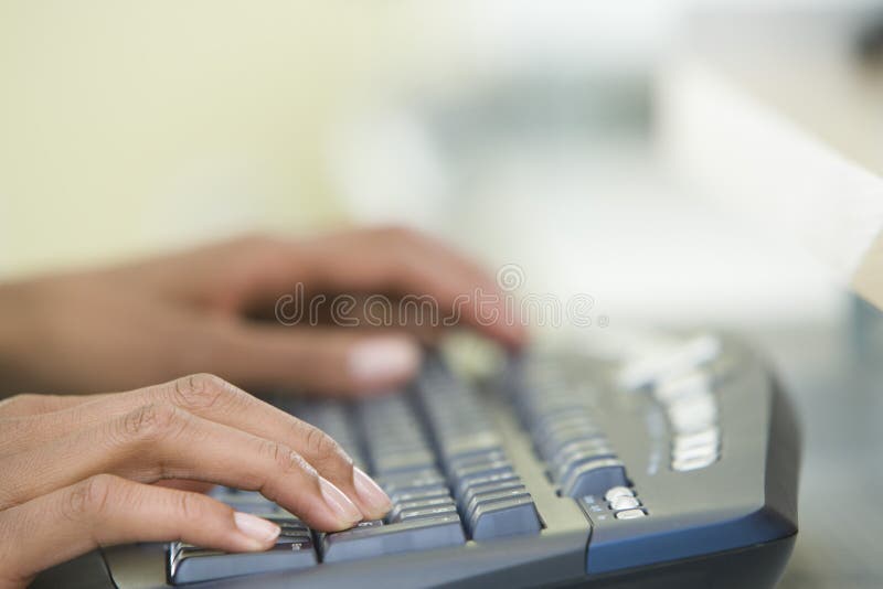 Las manos de la mujer que mecanografían en un teclado de ordenador