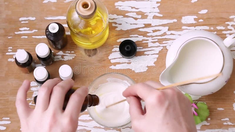 Las manos de las mujeres mezclan diferentes ingredientes naturales para la crema cosmética