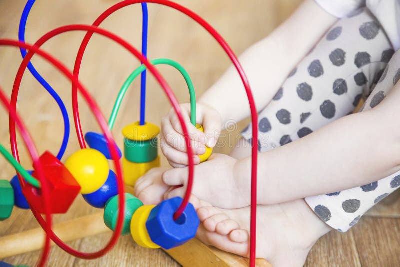 Las manos de una muchacha del niño que juega los juguetes E foto de archivo Las manos de una muchacha del niño que juega los juguetes E foto de archivo