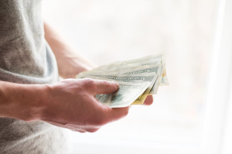 Las manos del hombre con los dólares en el fondo blanco Concepto financiero del negocio giva un soborno foto de archivo Las manos del hombre con los dólares en el fondo blanco Concepto financiero del negocio giva un soborno foto de archivo