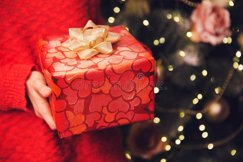 Las manos del ` s de la mujer que llevaban a cabo la Navidad o el Año Nuevo adornaron la caja de regalo foto de archivo libre de regalías Las manos del ` s de la mujer que llevaban a cabo la Navidad o el Año Nuevo adornaron la caja de regalo foto de archivo libre de regalías