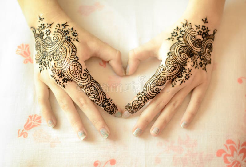 Beautiful drawing henna on female hands with mehndi decoration in heart shape. Love Concept. Beautiful drawing henna on female hands with mehndi decoration in heart shape. Love Concept.