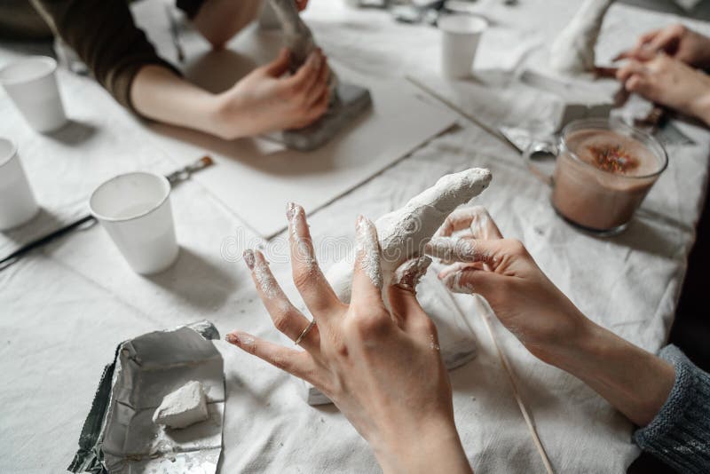 Las manos femeninas hacen moldes del plástico y del yeso en clase Taller y trabajo creativo del equipo fotos de archivo libres de regalías Las manos femeninas hacen moldes del plástico y del yeso en clase Taller y trabajo creativo del equipo fotos de archivo libres de regalías