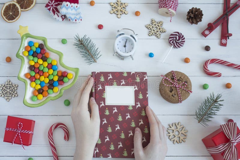Las manos femeninas sostienen el libro de la Navidad La Navidad foto de archivo libre de regalías Las manos femeninas sostienen el libro de la Navidad La Navidad foto de archivo libre de regalías