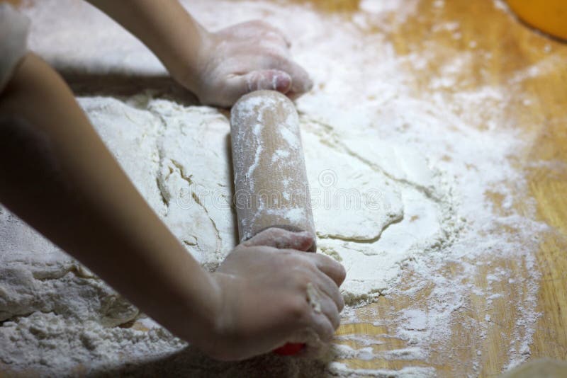 Las manos y la pasta de los niños Niño pequeño que amasa una pasta Concepto hecho a mano sano de la comida productos de la panade fotografía de archivo libre de regalías Las manos y la pasta de los niños Niño pequeño que amasa una pasta Concepto hecho a mano sano de la comida productos de la panade fotografía de archivo libre de regalías