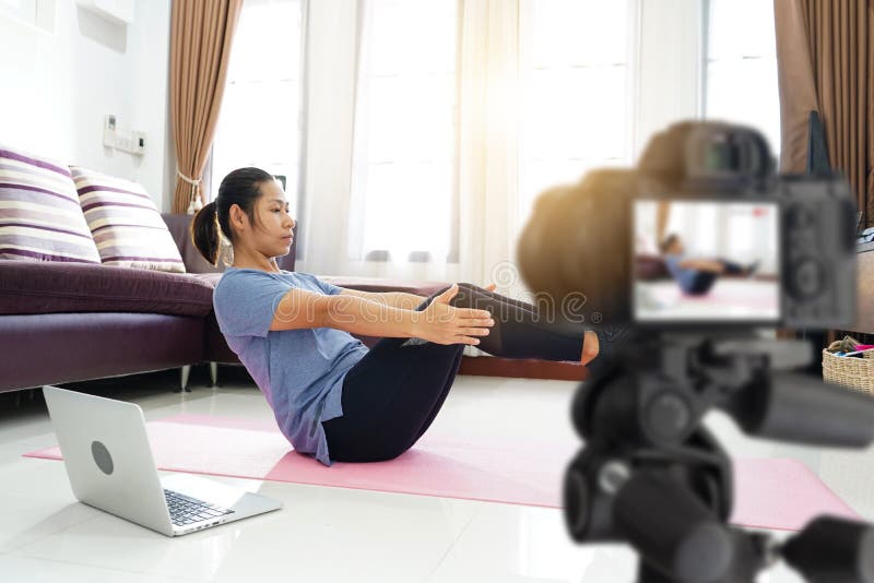 Asian woman exercise workout at home, With recording making video blogger camera for their blog. Asian woman exercise workout at home, With recording making video blogger camera for their blog