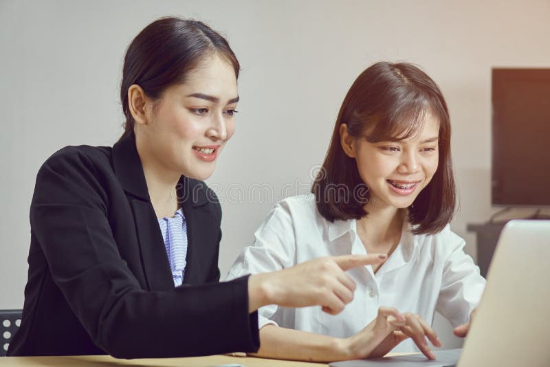 Las mujeres de negocios están utilizando los ordenadores portátiles y los smartphones para trabajar en la oficina fotos de archivo libres de regalías Las mujeres de negocios están utilizando los ordenadores portátiles y los smartphones para trabajar en la oficina fotos de archivo libres de regalías
