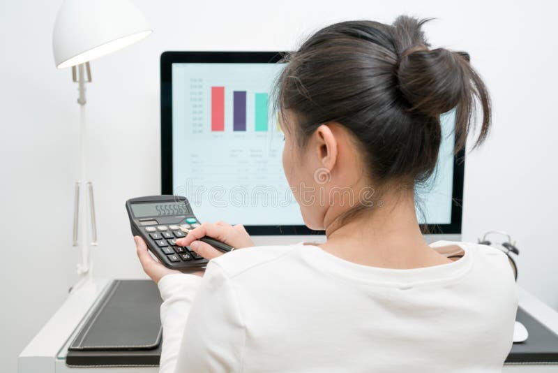 Las mujeres de negocios jovenes trabajan con la calculadora y mesa y pluma del ordenador en la tabla de trabajo moderna foto de archivo Las mujeres de negocios jovenes trabajan con la calculadora y mesa y pluma del ordenador en la tabla de trabajo moderna foto de archivo