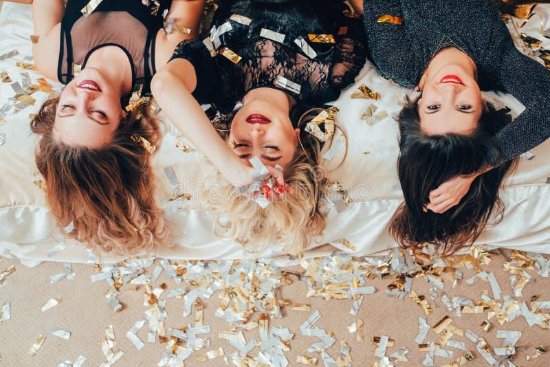 Las mujeres del partido descansan confeti de la cama del alivio de la relajación foto de archivo libre de regalías Las mujeres del partido descansan confeti de la cama del alivio de la relajación foto de archivo libre de regalías