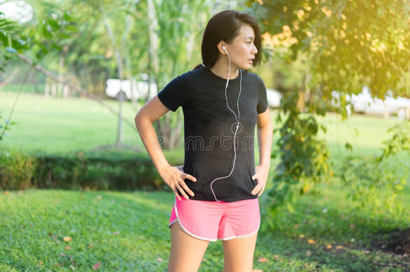 Las mujeres escuchan la música después de correr se relajan foto de archivo libre de regalías Las mujeres escuchan la música después de correr se relajan foto de archivo libre de regalías