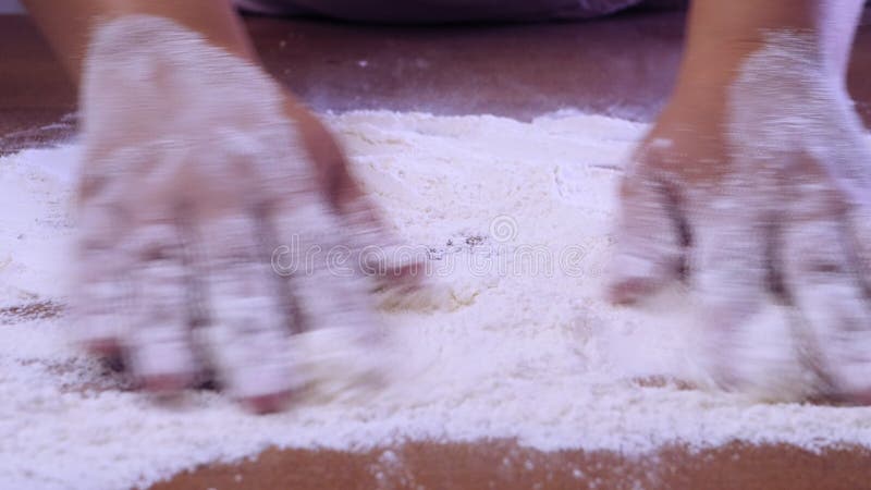 Las mujeres esparcen la harina blanca para cocinar sobre una mesa de madera