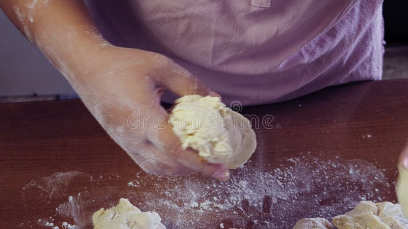 Las mujeres esparcen la harina blanca sobre una mesa de madera