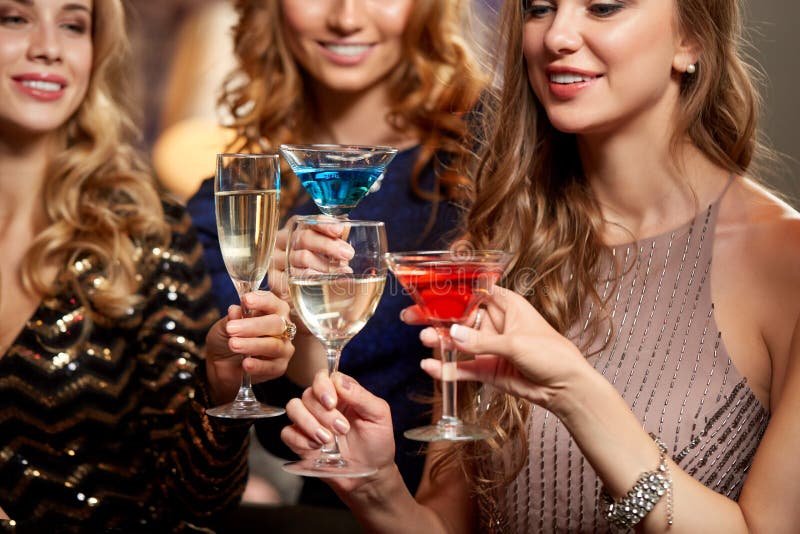 Las mujeres felices tomando una copa en la discoteca imagen de archivo