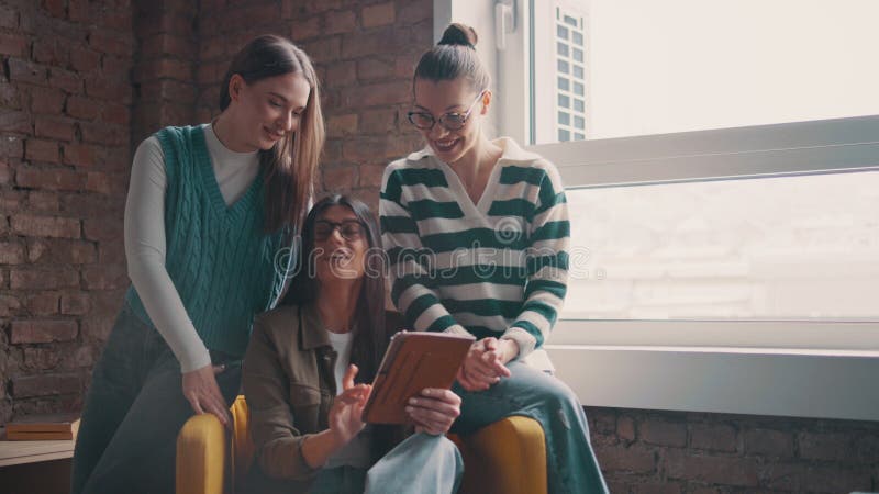 Las mujeres profesionales de los negocios colaboran por una ventana discutiendo ideas y formando ideas en una tableta almacen de metraje de vídeo