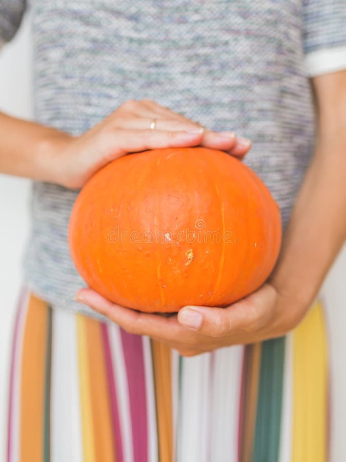 Las mujeres sostienen la calabaza en manos Día de fiesta de Halloween o de Thansgiving imagen de archivo libre de regalías Las mujeres sostienen la calabaza en manos Día de fiesta de Halloween o de Thansgiving imagen de archivo libre de regalías