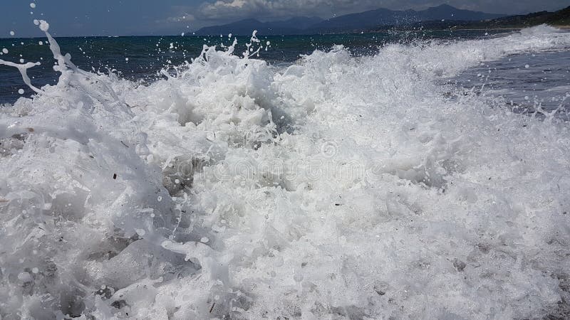 Las ondas salpican espuma en el mar Preveza Grecia del verano imagen de archivo Las ondas salpican espuma en el mar Preveza Grecia del verano imagen de archivo
