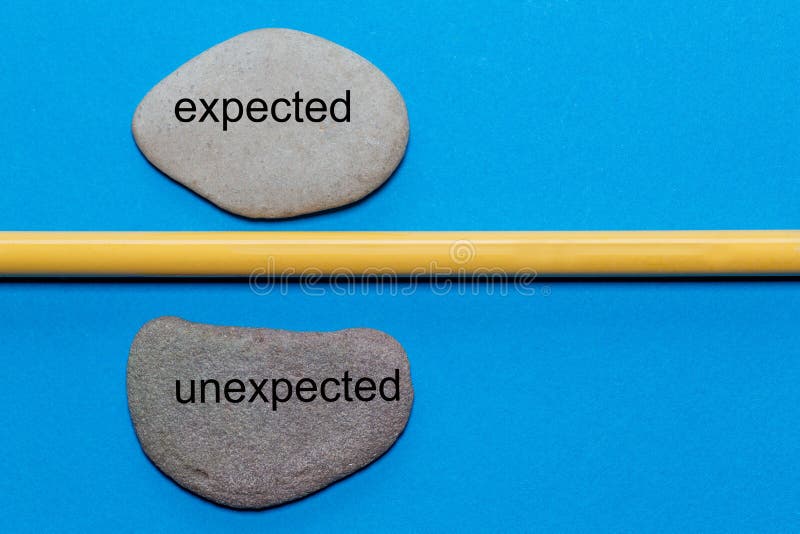 The words expected and unexpected are written on natural smooth stones separated by a yellow pencil. The background is isolated in blue and has a lot of space . The words expected and unexpected are written on natural smooth stones separated by a yellow pencil. The background is isolated in blue and has a lot of space .