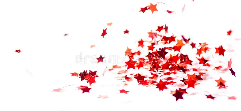 Las pequeñas estrellas brillantes rojas dispersadas del confeti vuelan