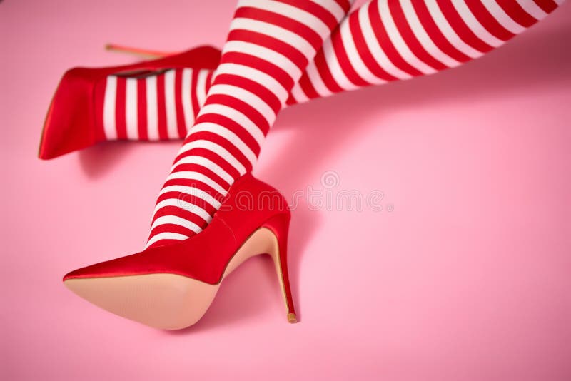 santa woman`s legs on a light pink background. santa woman`s legs on a light pink background