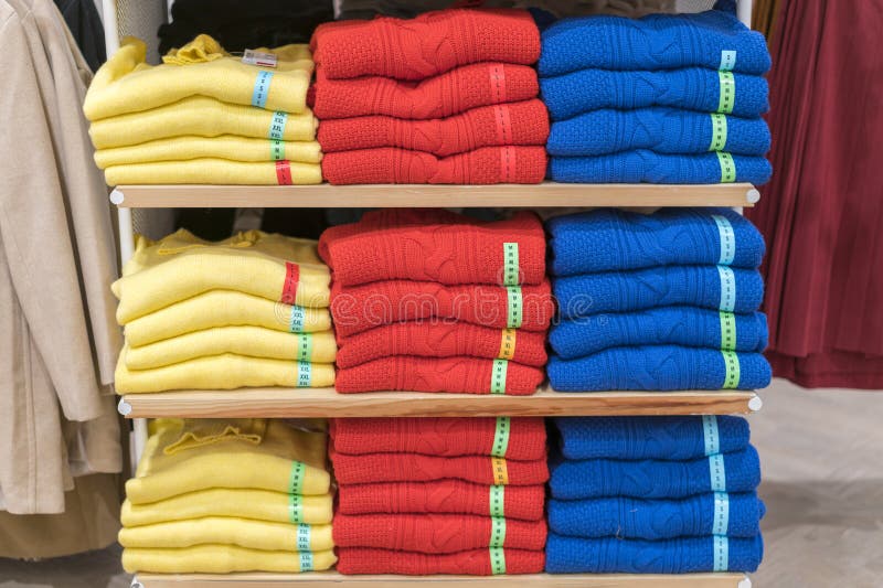 Las pilas aseadas de ropa doblada en la tienda dejan de lado Camisa del plegamiento del color en una tienda de ropa cuidadosament fotografía de archivo libre de regalías Las pilas aseadas de ropa doblada en la tienda dejan de lado Camisa del plegamiento del color en una tienda de ropa cuidadosament fotografía de archivo libre de regalías