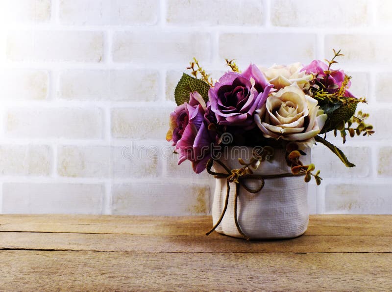 Las rosas rosadas artificiales florecen en florero en el papel pintado de madera y del espacio imagen de archivo libre de regalías Las rosas rosadas artificiales florecen en florero en el papel pintado de madera y del espacio imagen de archivo libre de regalías